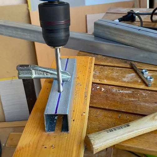 Bricolaje para van overland: taladrando un perfil metálico con línea guía sobre tabla de madera, fijado con sargento FIHER