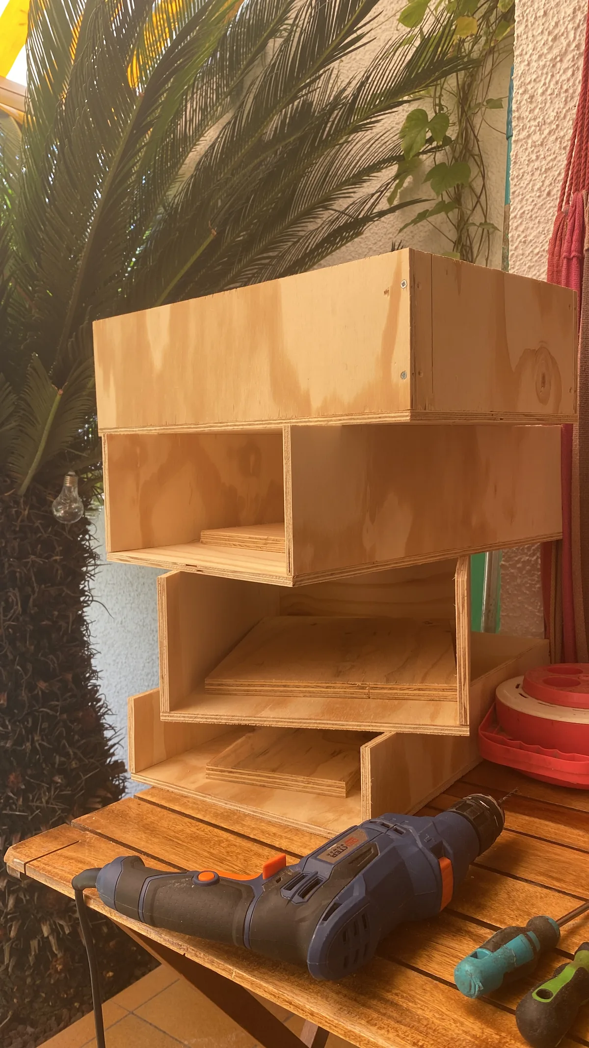 Construcción de módulos organizadores de madera para furgoneta camper, mostrando el taladro y el diseño modular