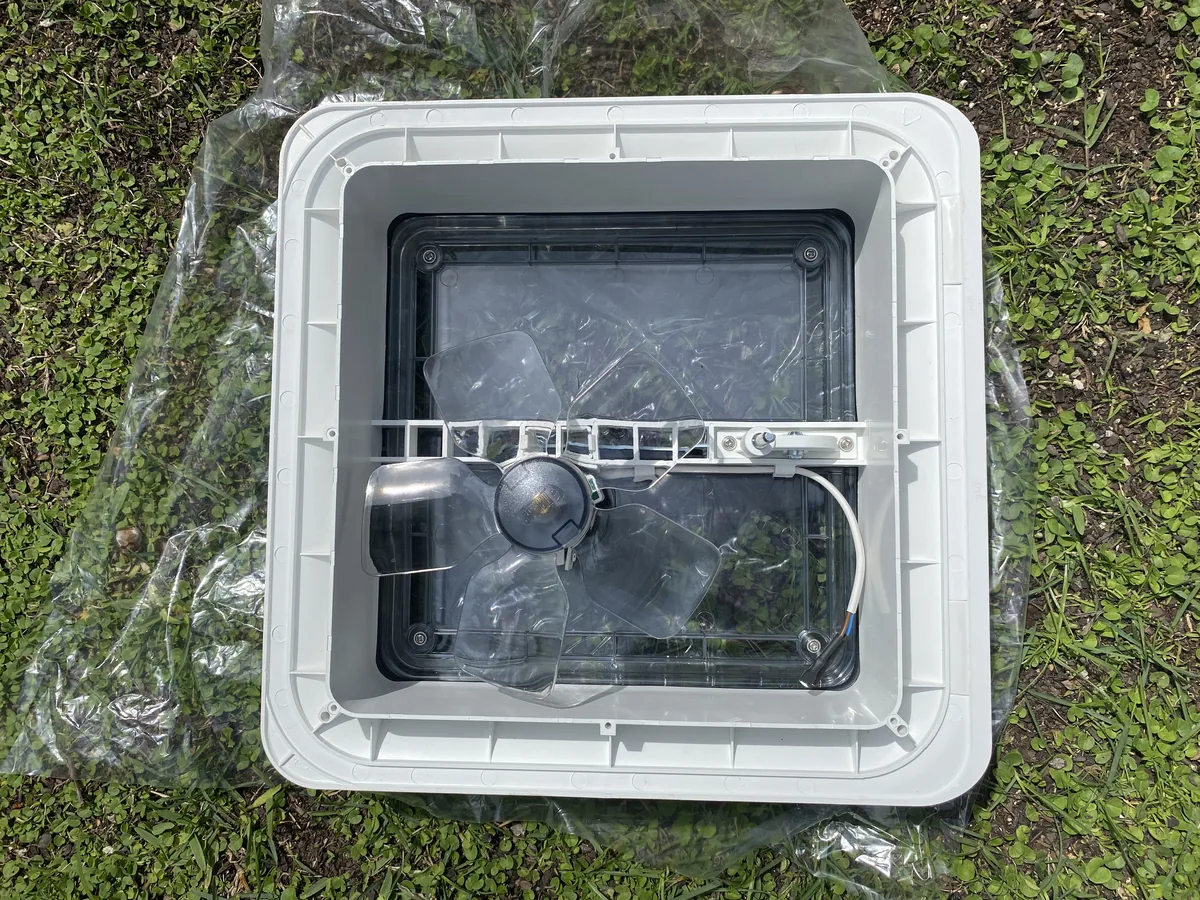 Nueva claraboya de techo blanca con ventilador para mejorar la ventilación en tu furgoneta camper overland, sobre pasto