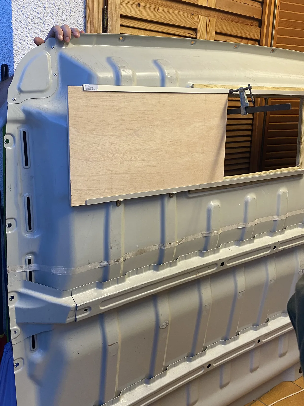 Preparando la apertura de ventana en panel de furgoneta. Fijando pieza de madera con sargento para camperización