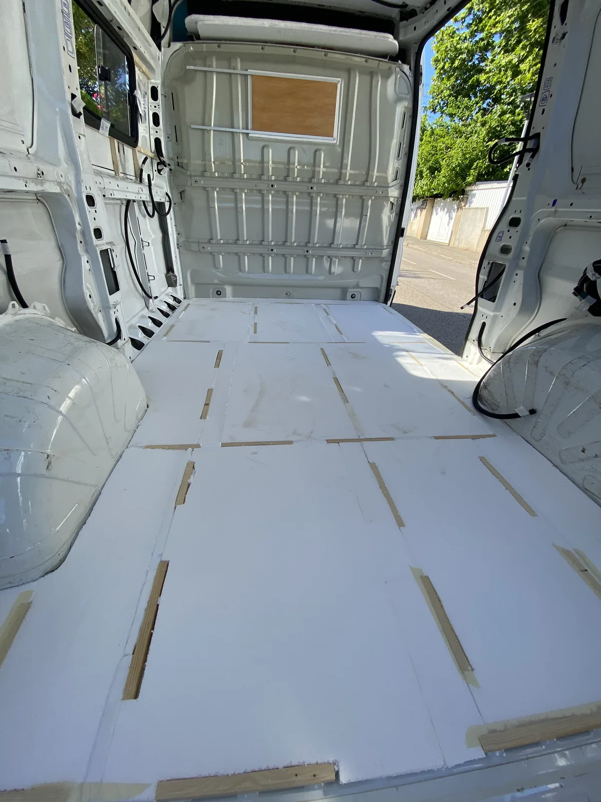Suelo de furgoneta camper en proceso de aislamiento con paneles de XPS y listones de madera para viajes overland