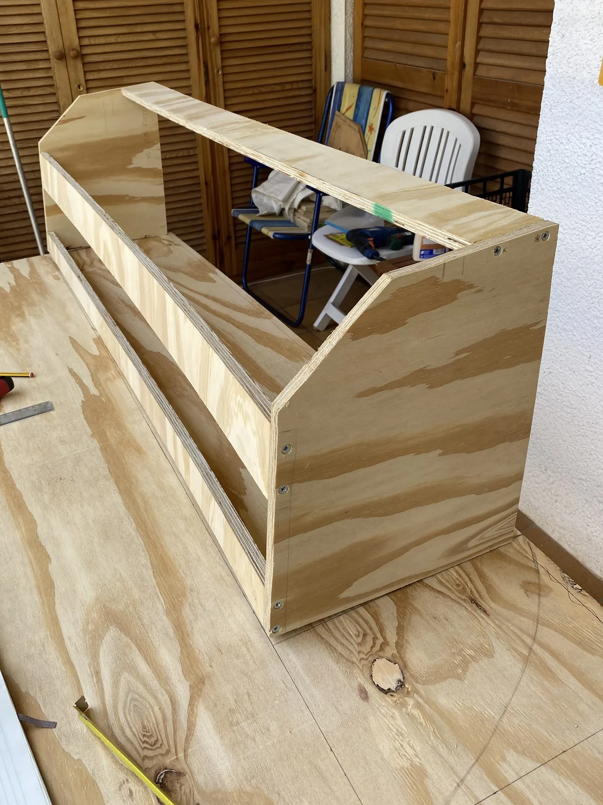 Mueble DIY de contrachapado en construcción para la camperización de furgoneta, creando almacenamiento a medida