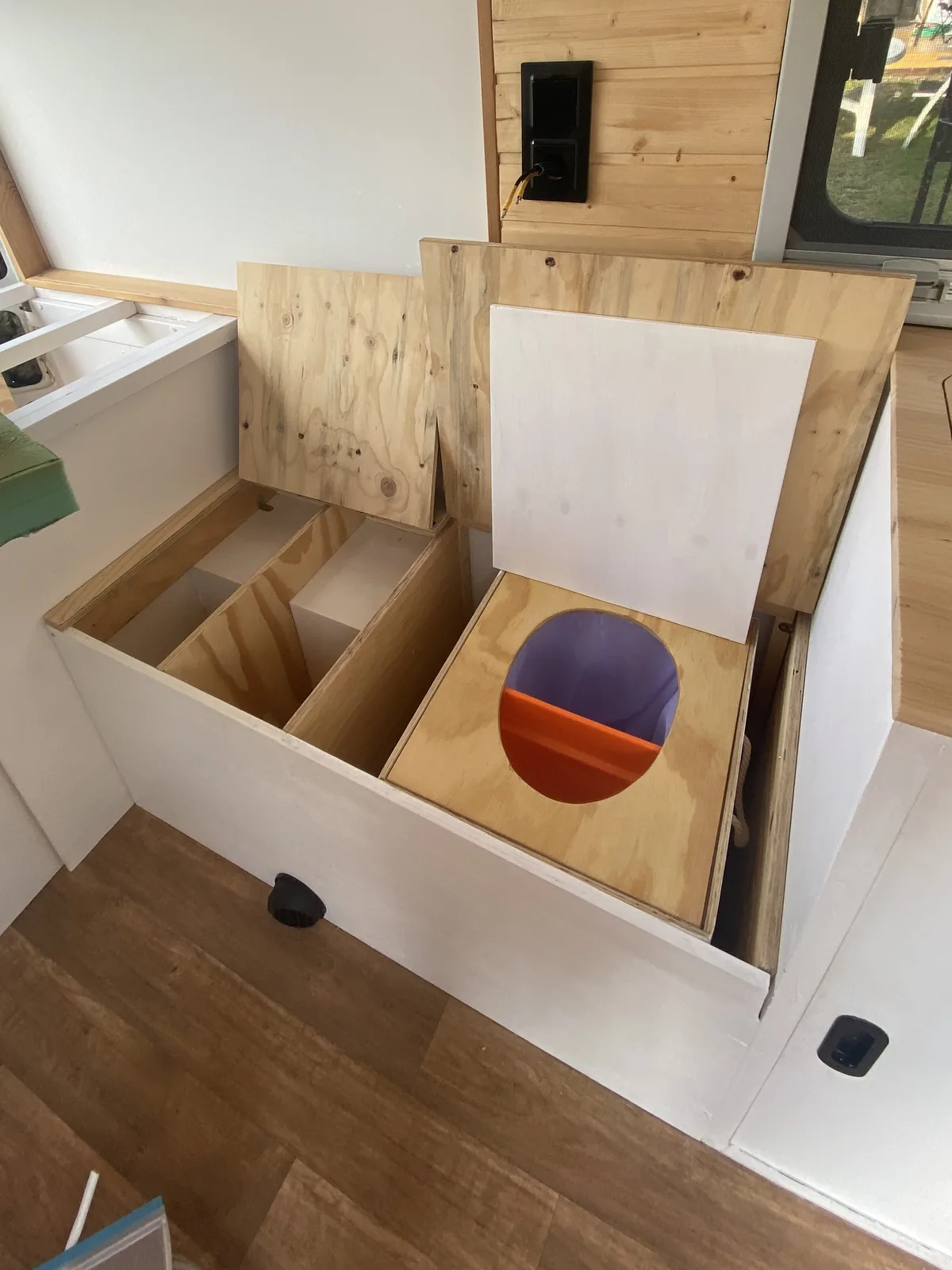Interior de furgoneta camper con mueble de almacenamiento personalizado y baño seco de separación para viajes overland
