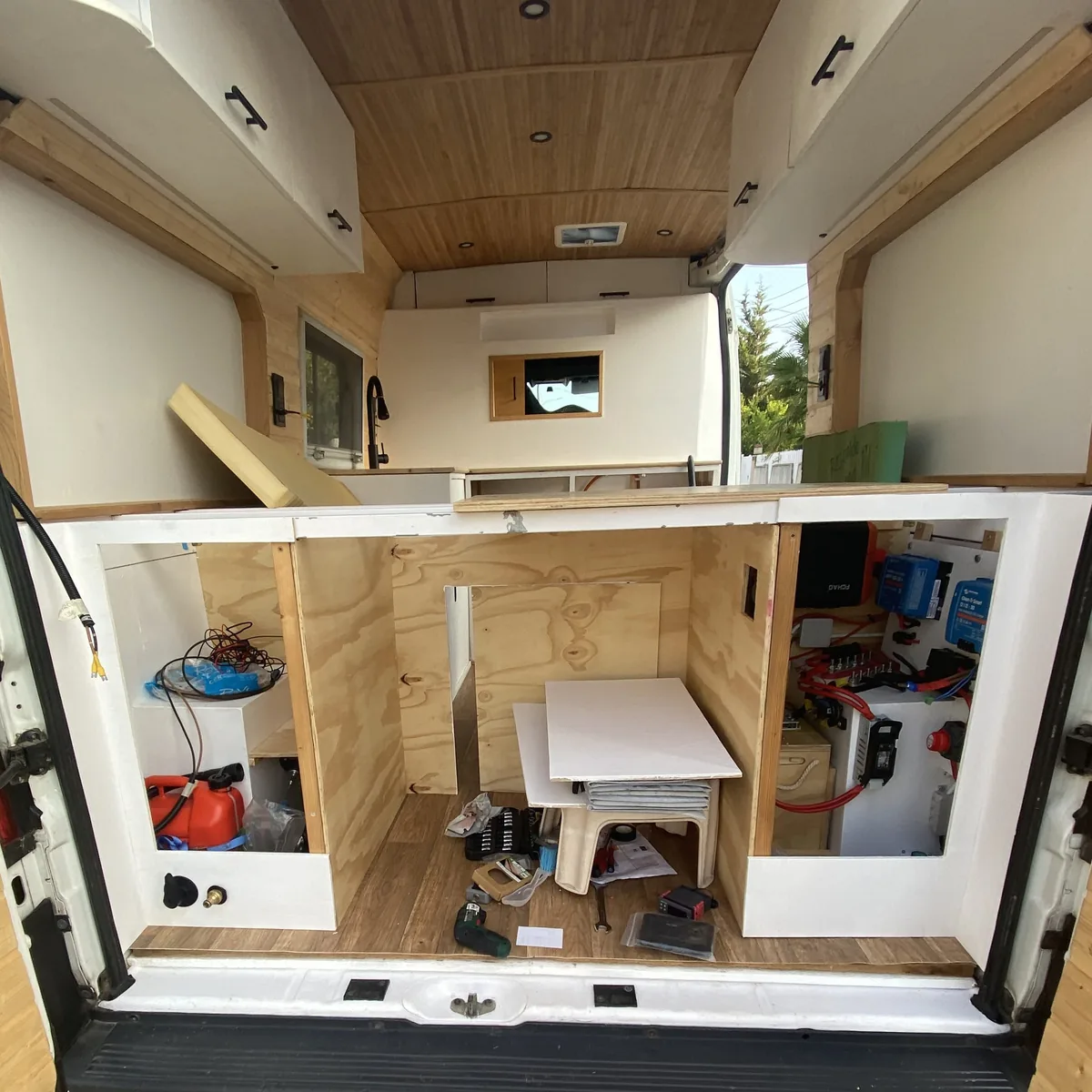 Furgoneta camper en construcción, interior con muebles de madera contrachapada, sistema eléctrico Victron y fregadero