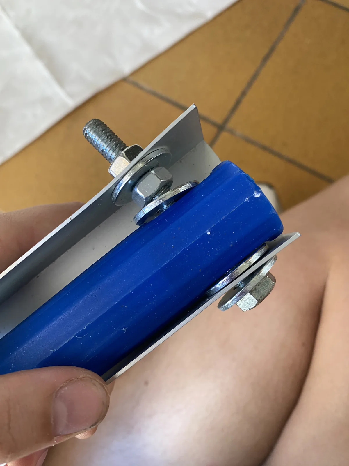 Montaje de un soporte artesanal para camperización: tubo de PVC azul fijado a perfil metálico con tornillos y tuercas