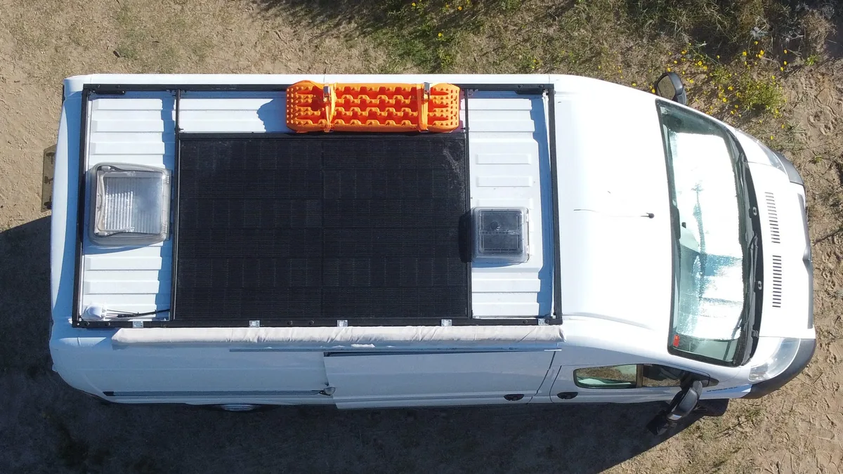 Vista aérea del techo de la furgoneta camper con el panel solar monocristalino instalado