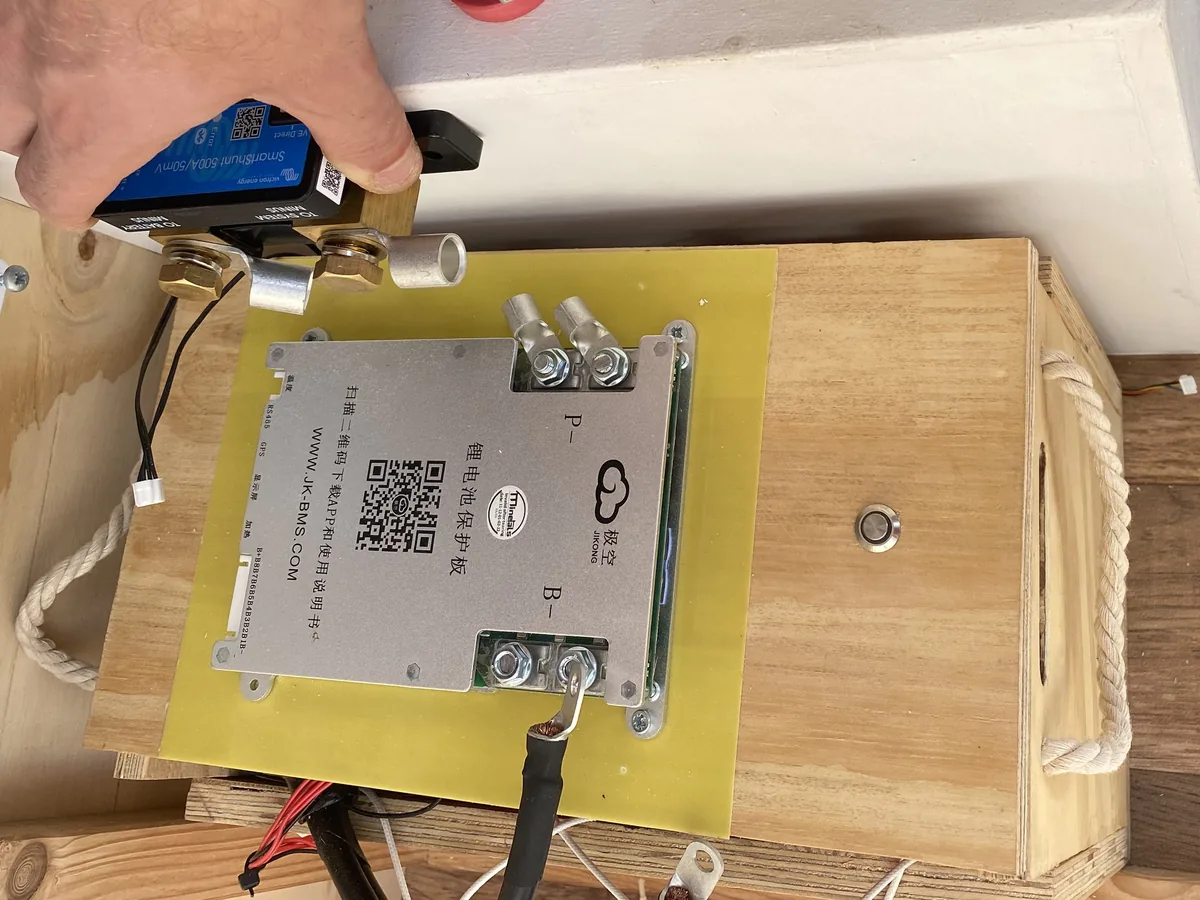 Mano instalando Victron SmartShunt y JK-BMS en el sistema de gestión de energía para van overland