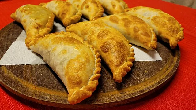 Deliciosas empanadas caseras recién horneadas en una tabla de madera, el bocado perfecto en cualquier aventura overland