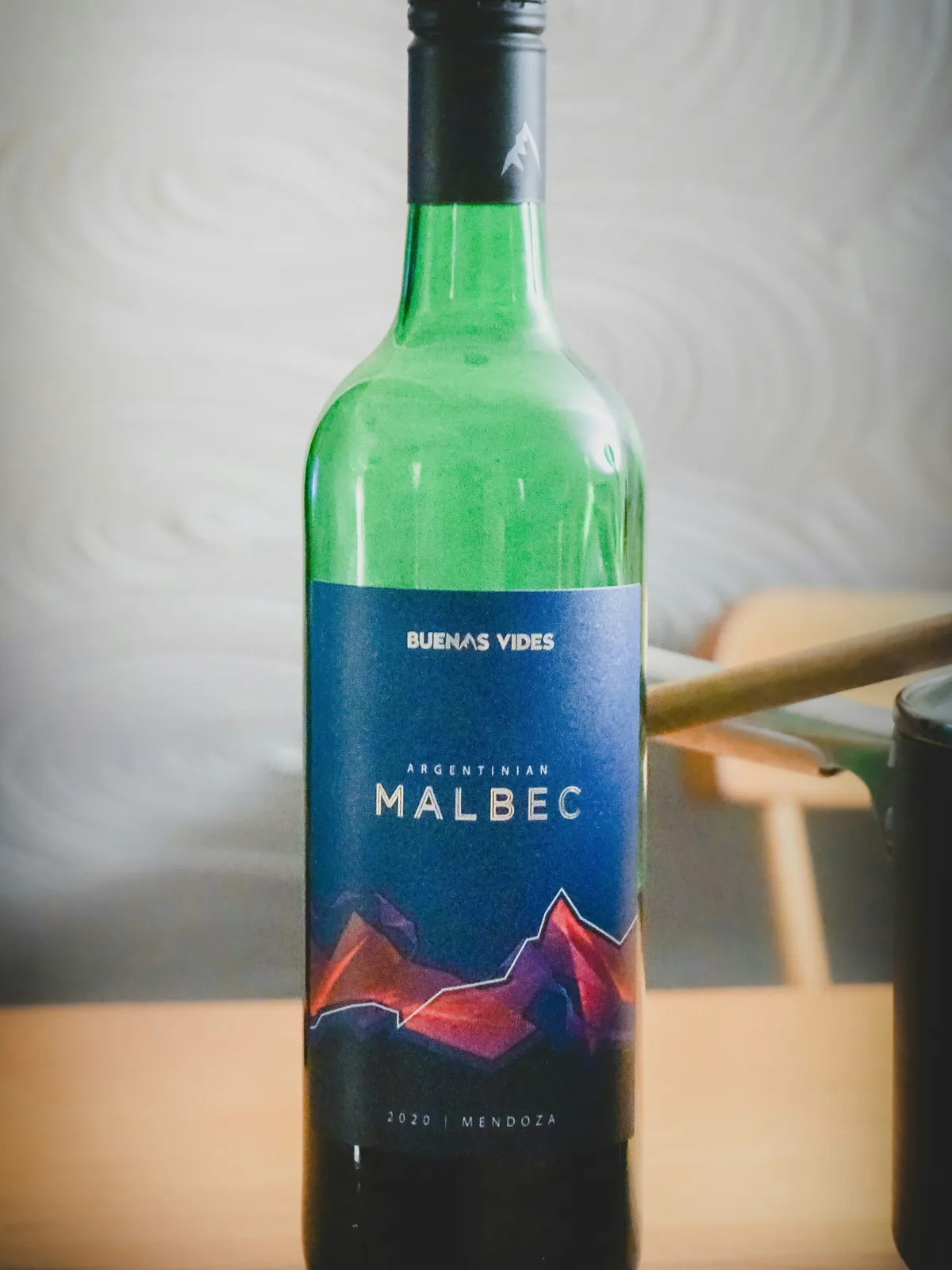 Botella de Malbec argentino de Mendoza, con diseño de montañas en la etiqueta, ideal para disfrutar en una aventura overland