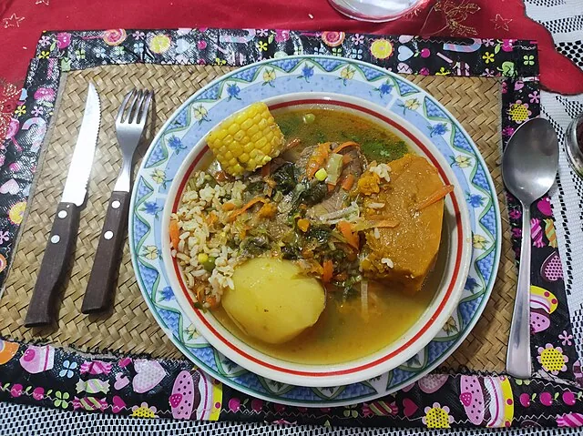 Plato de sancocho con carne, mazorca de maíz, papa, auyama y arroz, una comida casera sustanciosa para la ruta overland