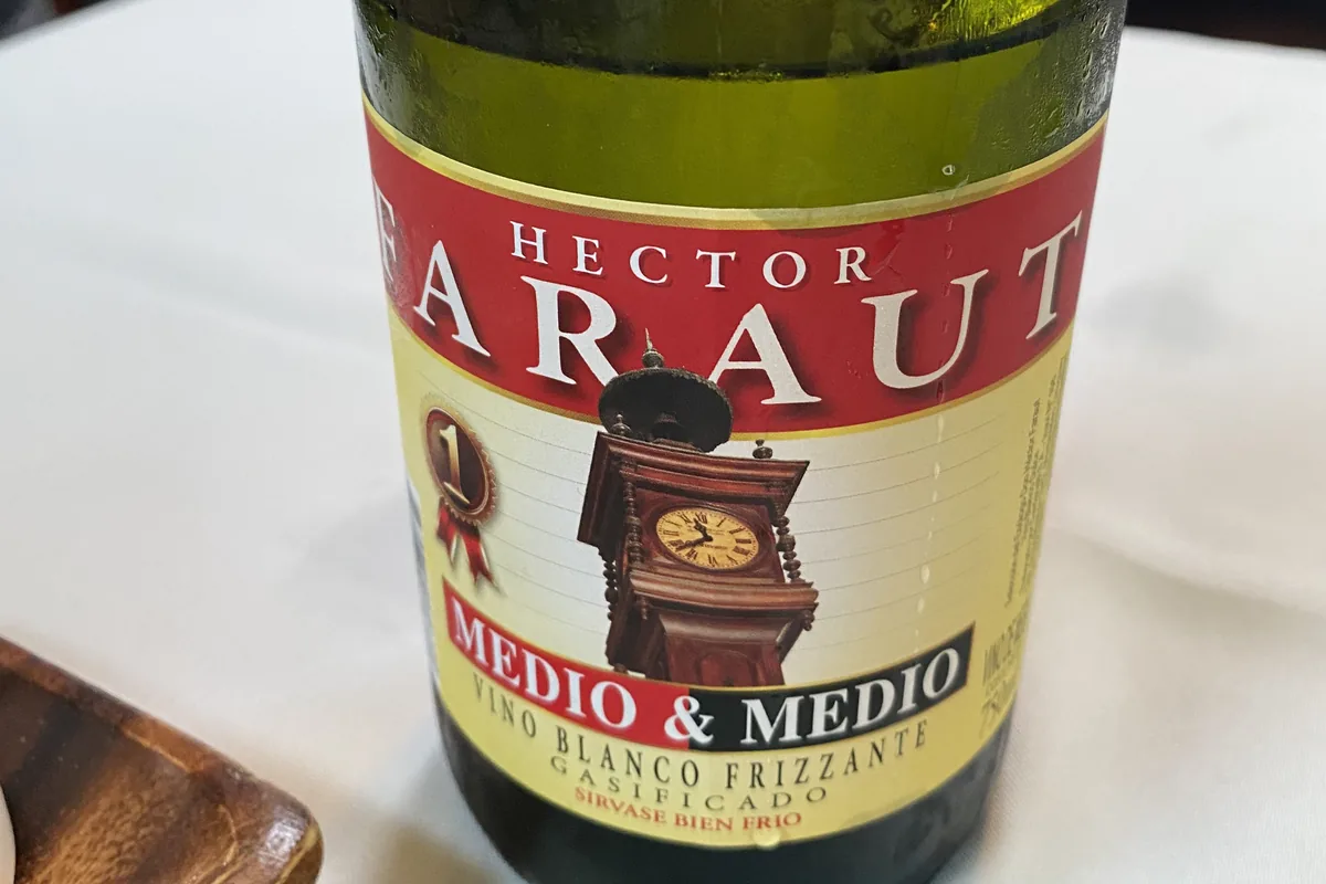 Botella de vino blanco frizzante Hector Saraut Medio & Medio, fría con gotas de condensación sobre su etiqueta