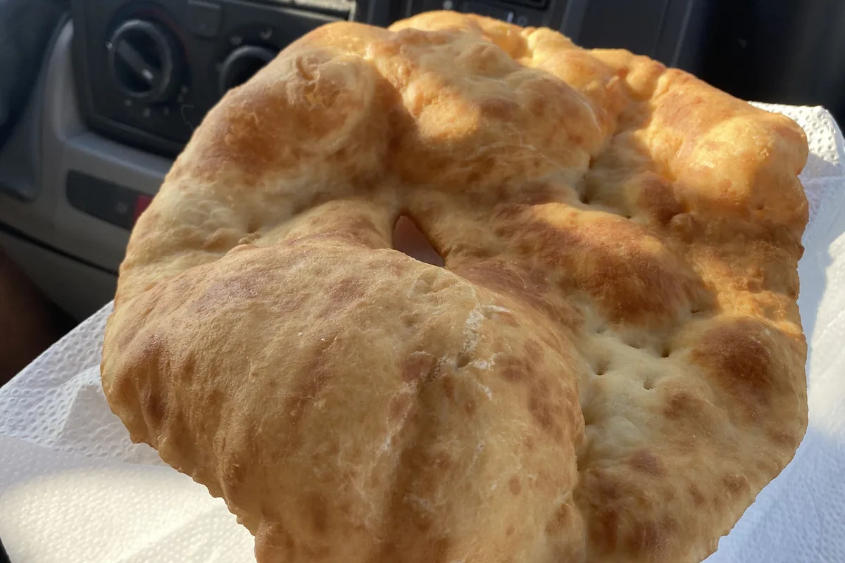 Deliciosa torta frita recién hecha, lista para comer en el interior de nuestra van camper durante un viaje overland