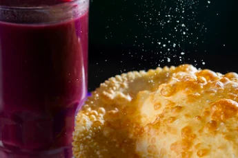 Pastel frito burbujeante espolvoreado con azúcar y bebida de frutas, un tentempié local en nuestra ruta overland