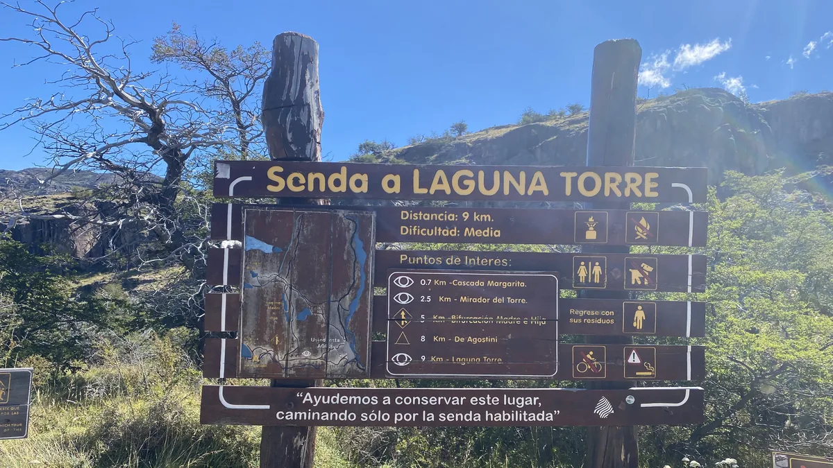 Cartel informativo de la Senda a Laguna Torre en El Chaltén, Patagonia, con distancia de 9km y dificultad media