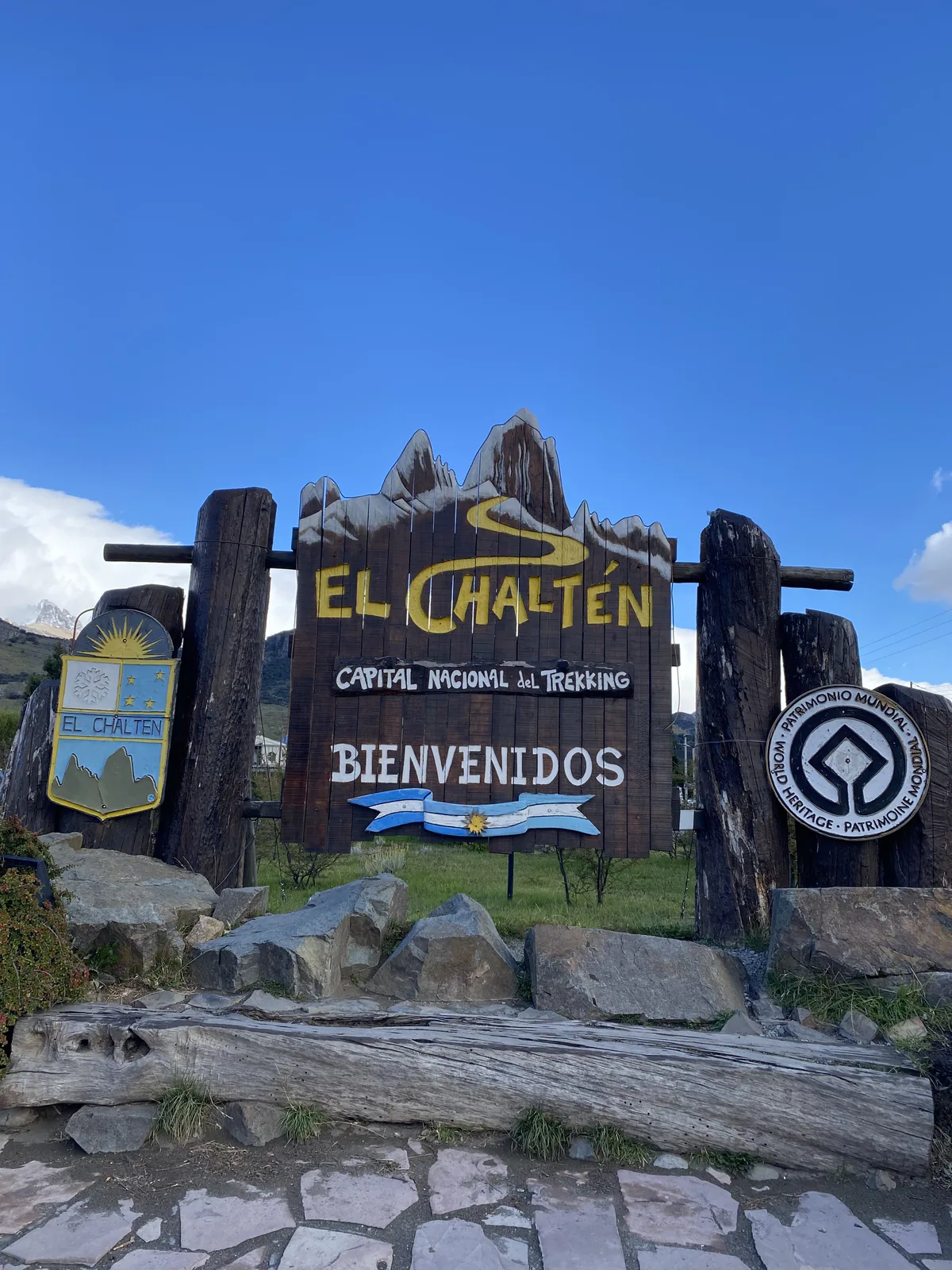 Cartel de bienvenida a El Chaltén, Capital Nacional del Trekking y Patrimonio Mundial, con montañas en Patagonia argentina