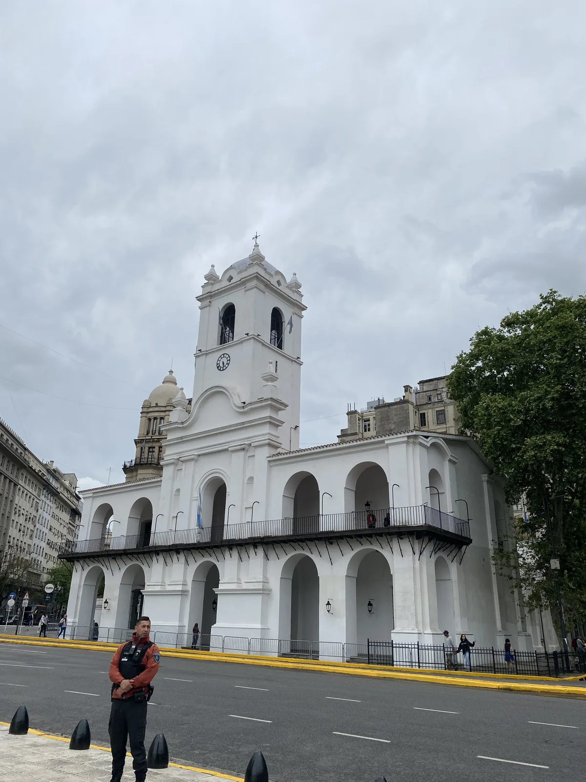 Rodando por Buenos Aires: el Cabildo colonial con arcos y torre, guardia en la avenida en un día nublado