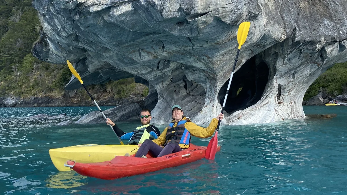 Pareja en kayaks explorando las icónicas Capillas de Mármol en Lago General Carrera, Chile. Aguas turquesas y cuevas rocosas