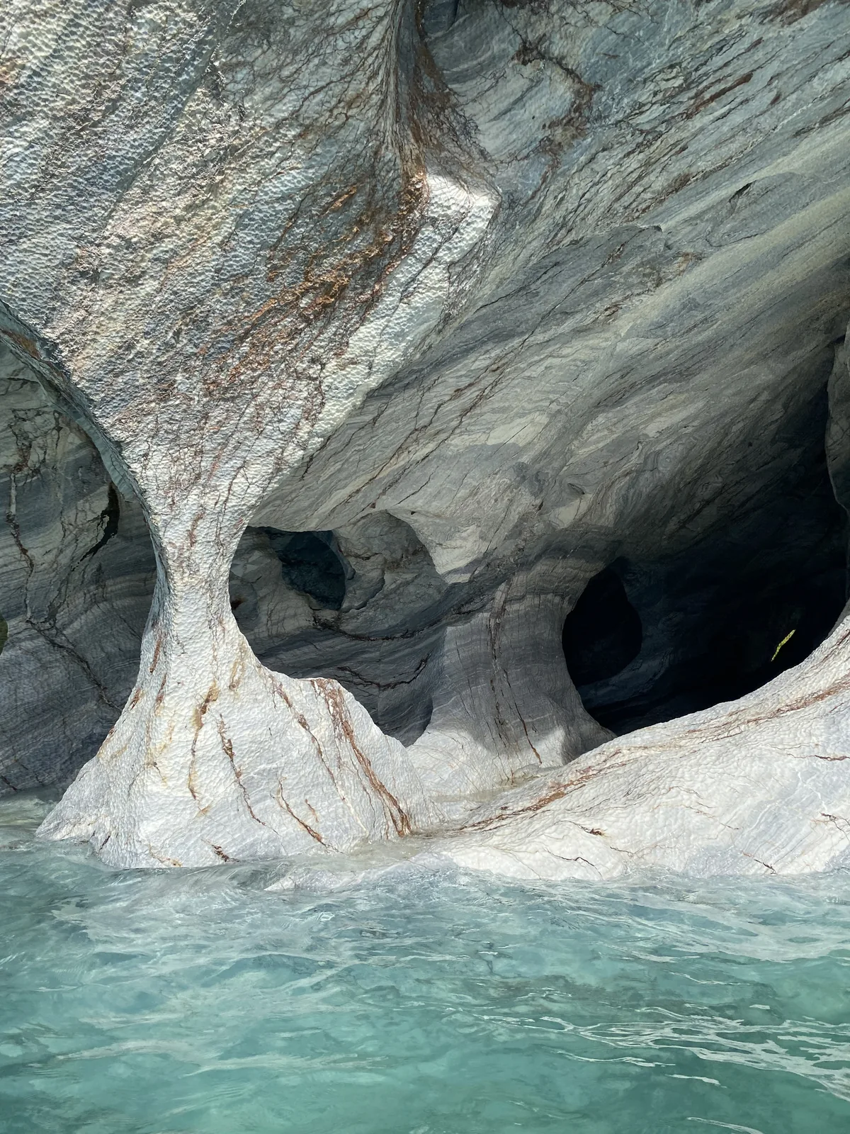 Columnas de mármol cinceladas por el tiempo sobre agua turquesa en las Capillas de Mármol, Patagonia chilena