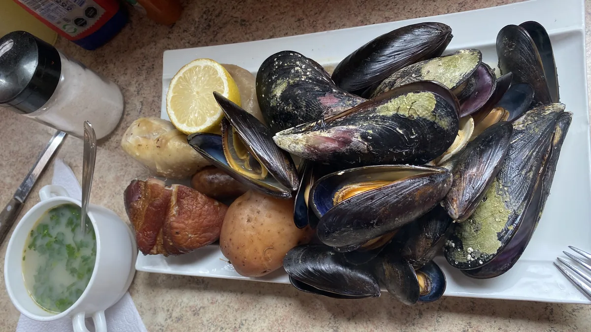 Mariscada con mejillones, patatas, carne ahumada, limón y sopa, disfrutando sabores locales en ruta