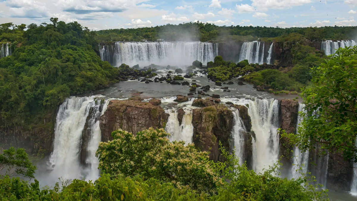 Vista panorámica de las majestuosas Cataratas del Iguazú con múltiples saltos de agua rodeados de densa selva tropical