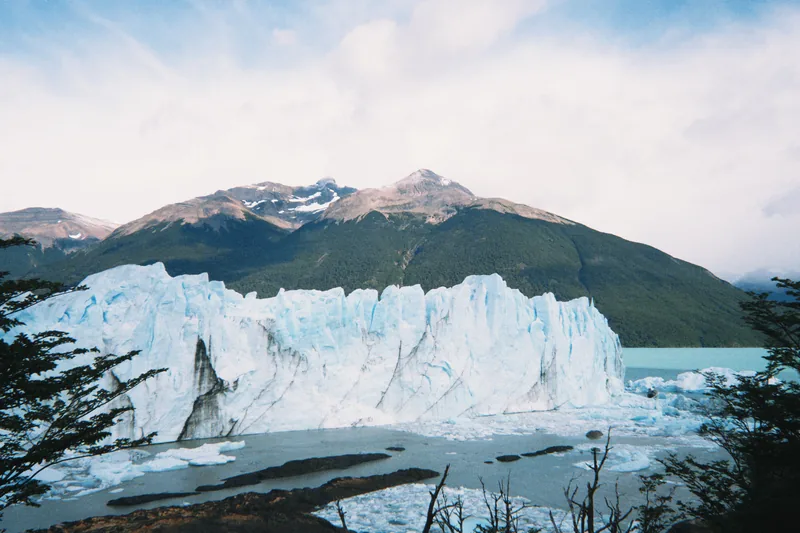 Imponente pared de hielo del Glaciar Perito Moreno en el Parque Nacional Los Glaciares, Argentina, con lago y montañas