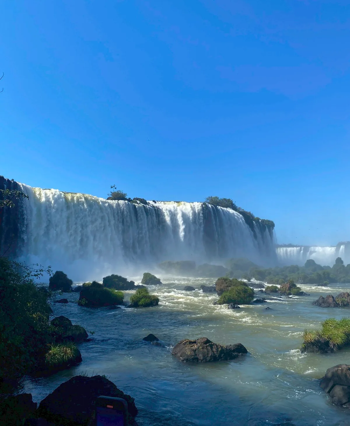 Laura en una pasarela con las cataratas al fondo.