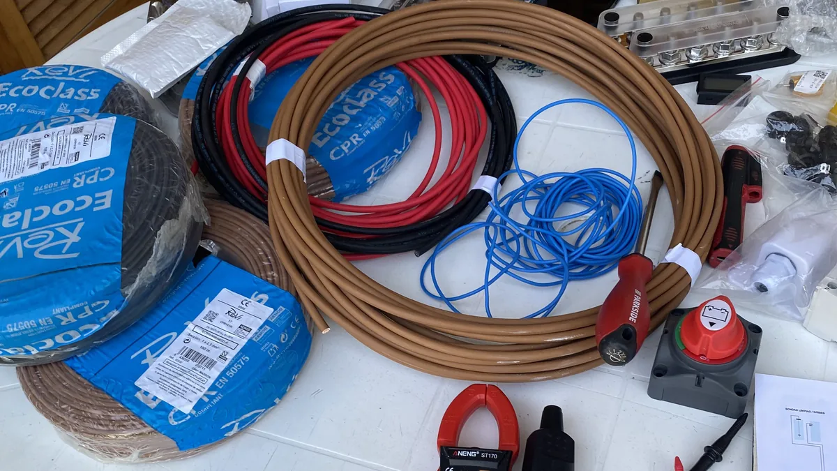 Material eléctrico para instalación en furgoneta camper: cables de cobre, interruptor de batería, fusibles y herramientas