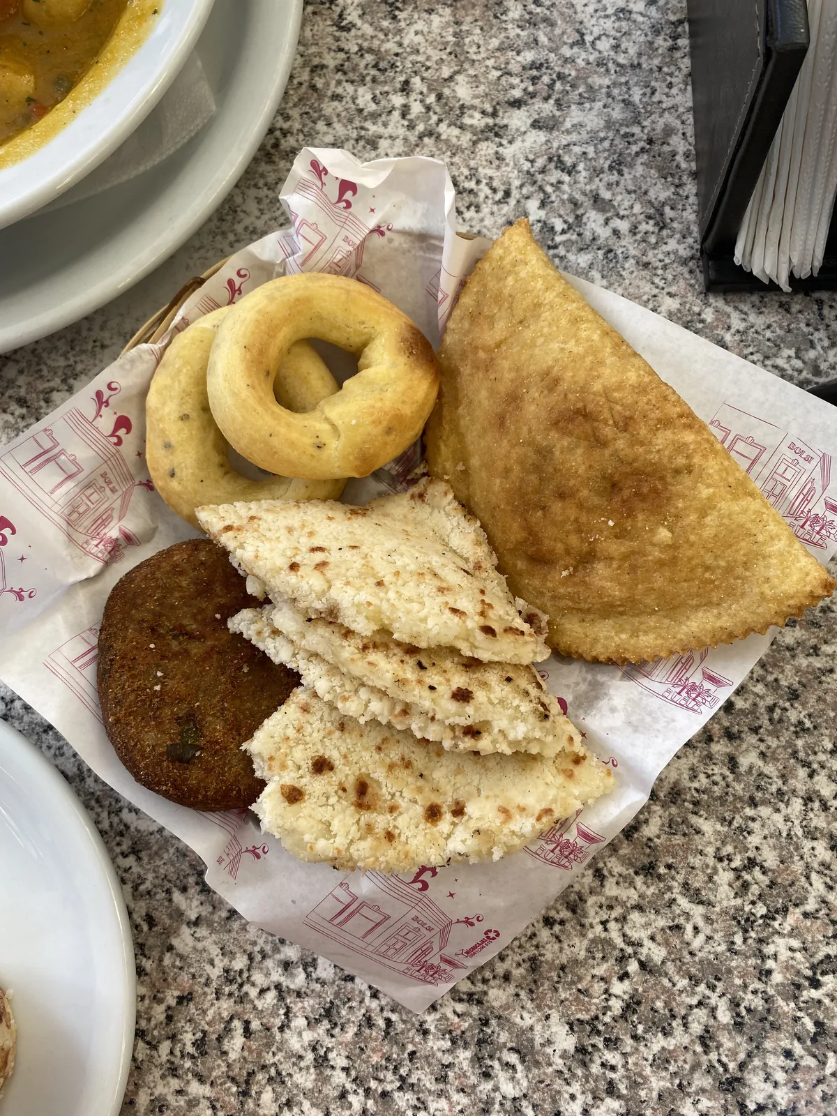 Cesta con fritos y panes locales: empanada, rosquillas, tortitas de maíz y papa rellena. Desayuno de viaje overland
