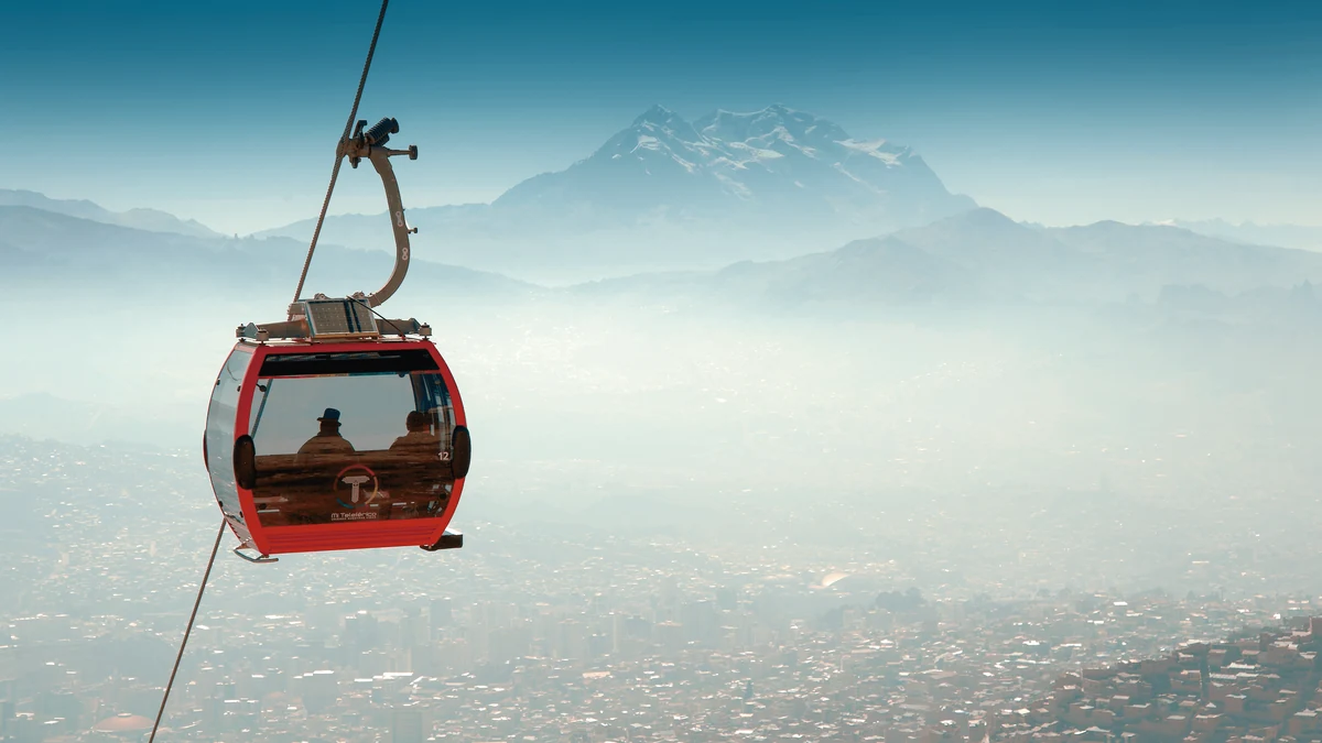 Teleférico rojo de Mi Teleférico sobre la ciudad de La Paz, Bolivia, con el majestuoso Illimani nevado al fondo