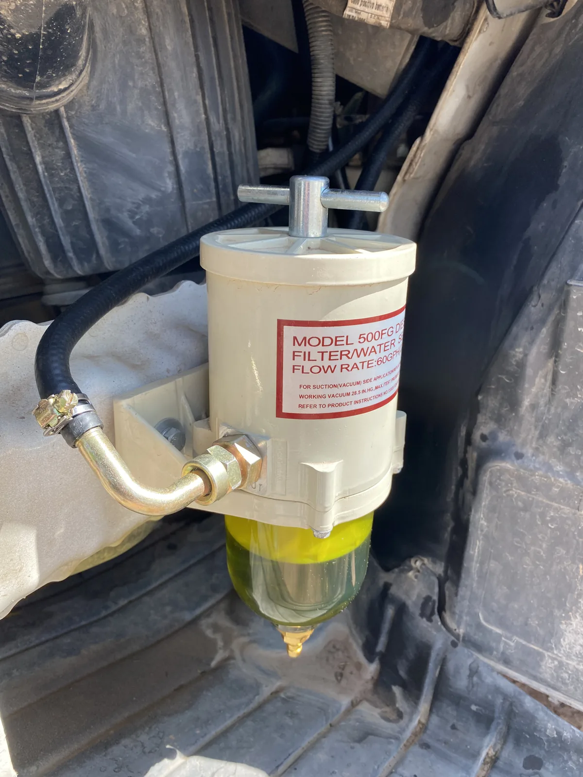 Filtro separador de agua/combustible Model 500FG instalado en motor de vehículo overland, con diésel en el recipiente