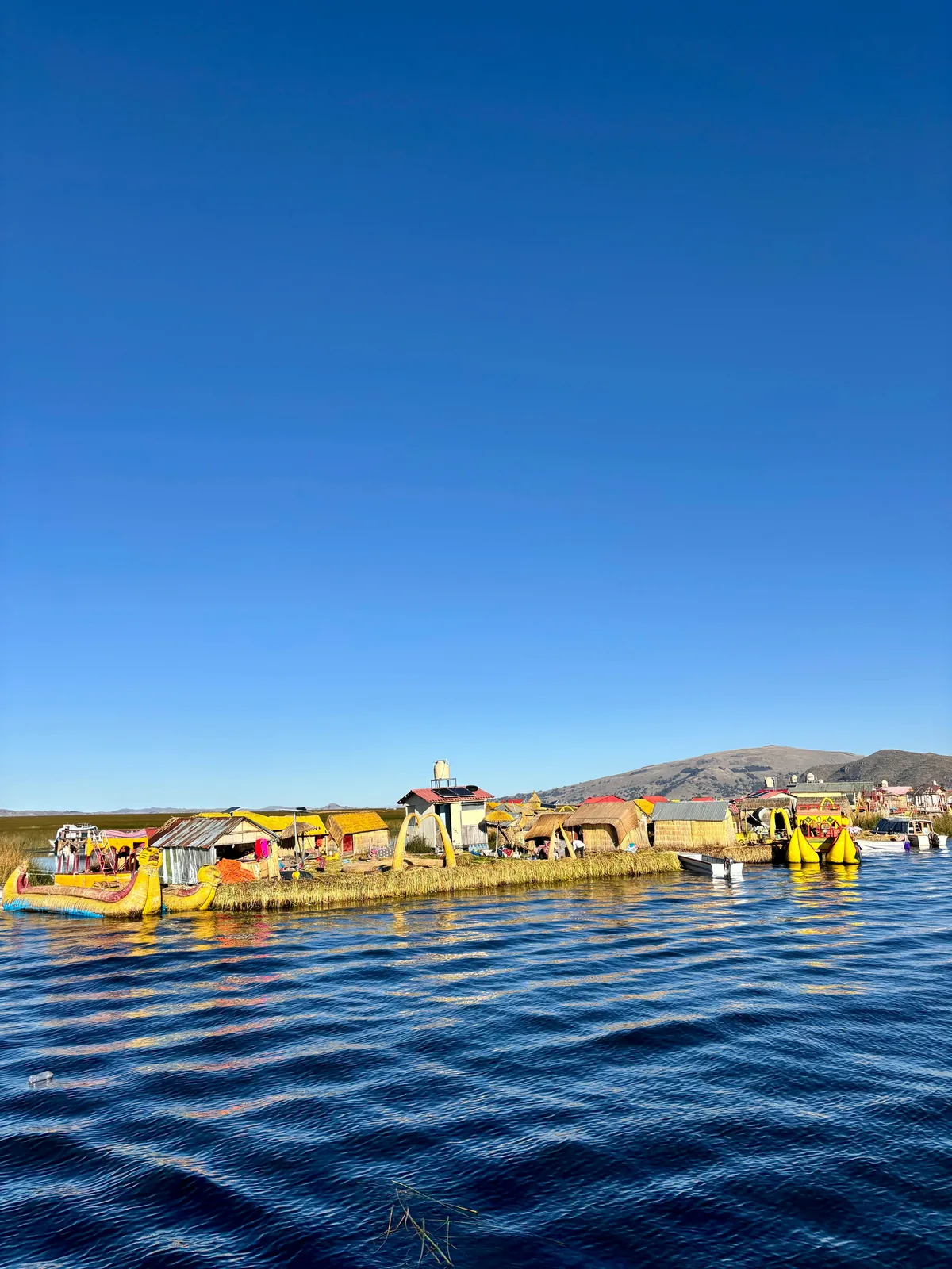 Explorando las islas Uros flotantes del Lago Titicaca, Perú, con coloridas casas y balsas de totora bajo un cielo azul brilla