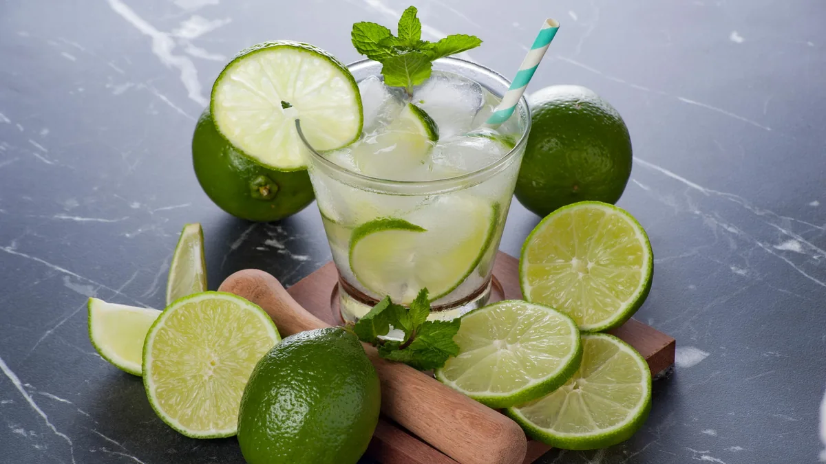 Bebida fría de lima con hielo y menta, ideal para un día caluroso en ruta. Incluye limas frescas y mortero de madera