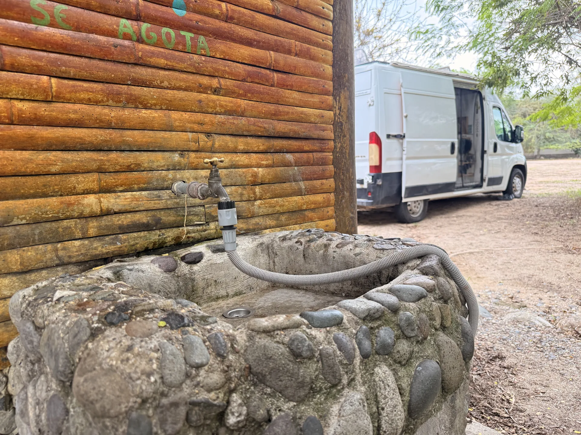 Furgoneta camper llenando el depósito de agua de una fuente