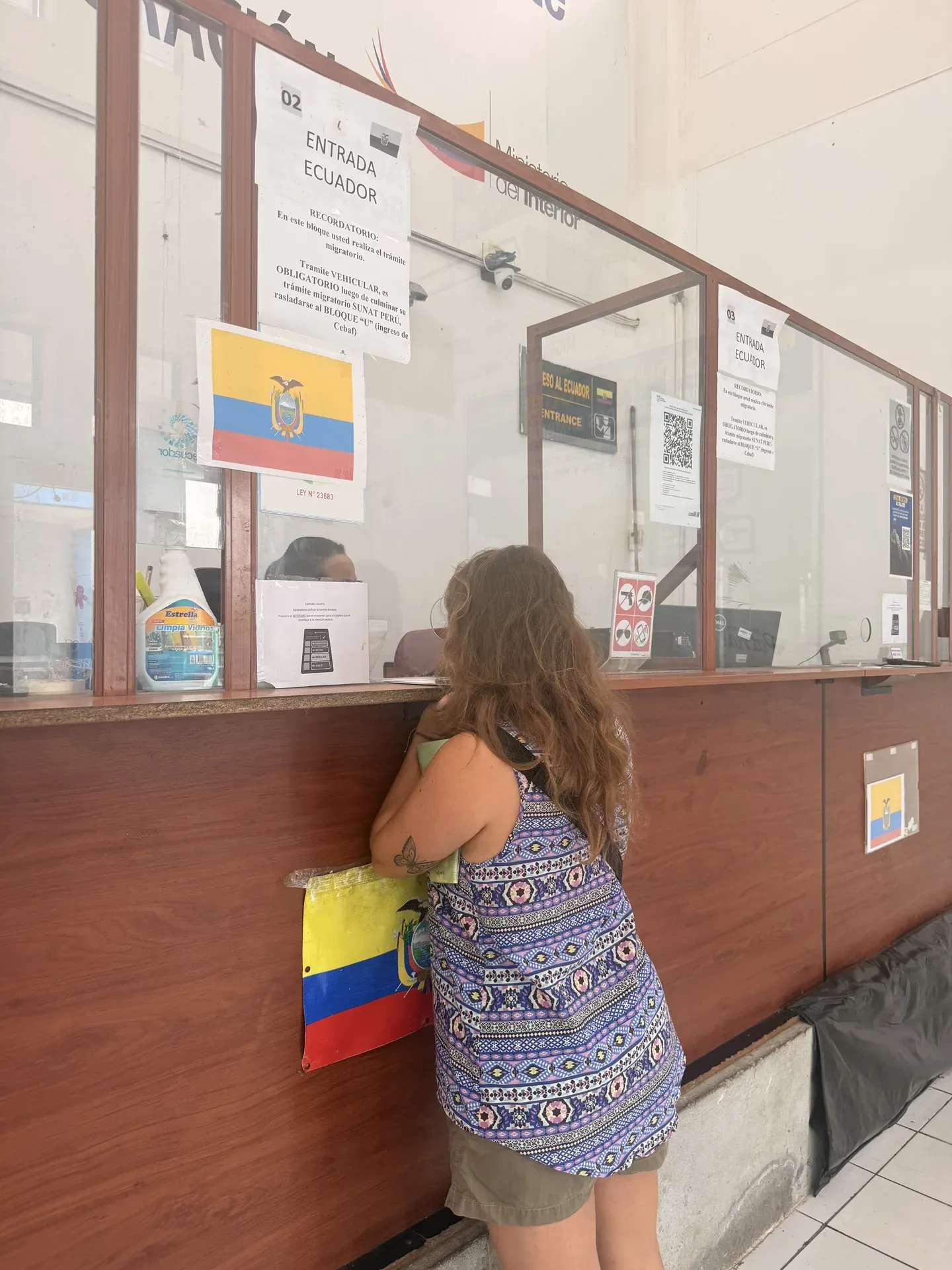Mujer esperando en una taquilla de un paso fronterizo