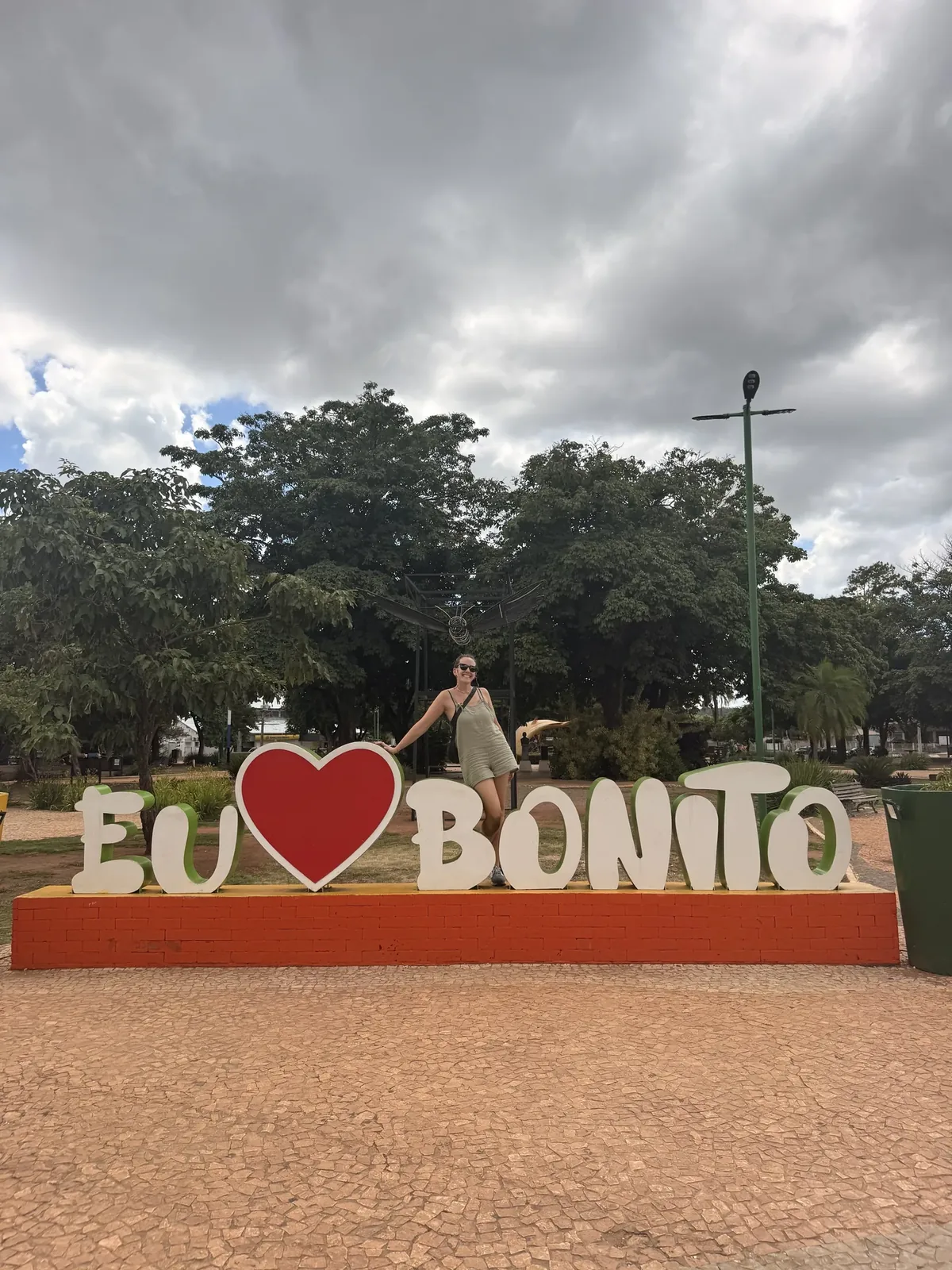Mujer posando junto al cartel de la ciudad de Bonito, Brasil