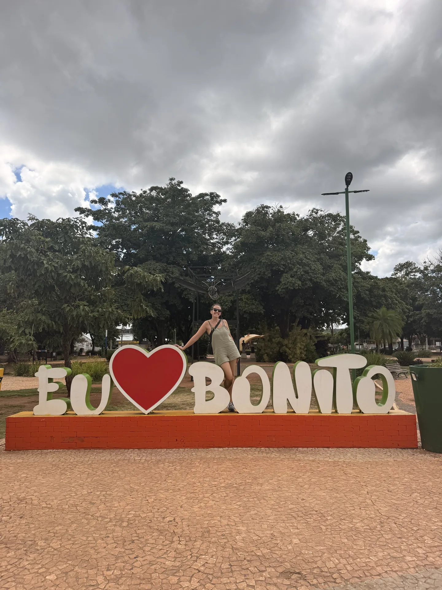 Mujer posando junto al cartel de la ciudad de Bonito, Brasil