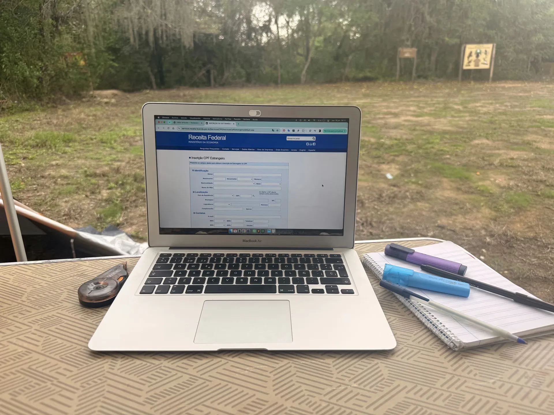 Ordenador portátil navegando en Internet con una libreta y dos boligrafos al costado