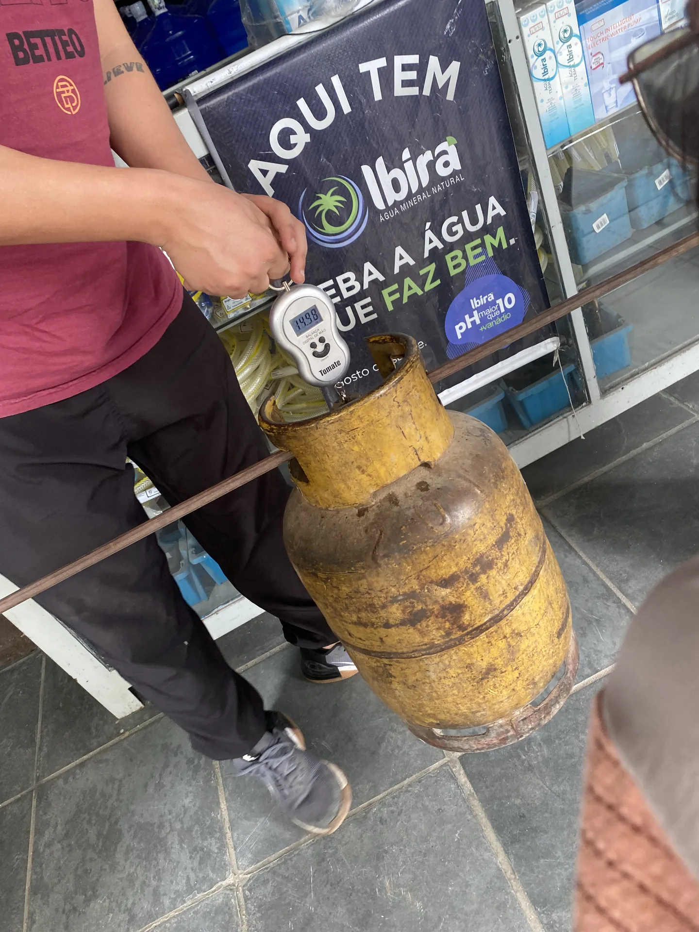 Persona pesando una garrafa de gas antes de llenarla