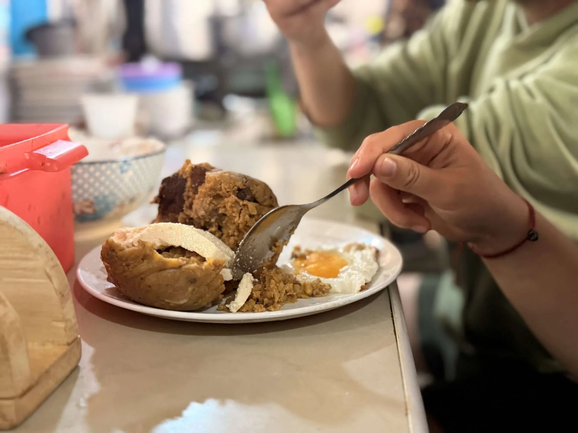 Bolón de verde relleno con huevo frito, comida callejera típica de Ecuador
