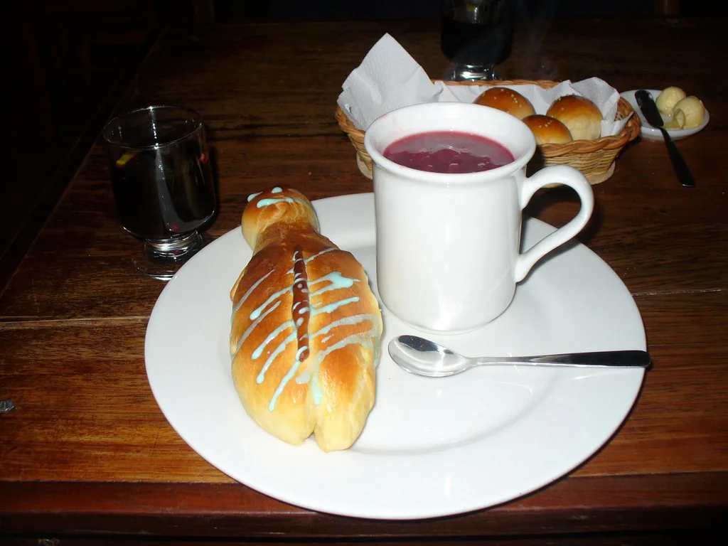 Colada morada caliente servida con una guagua de pan en el Día de Difuntos