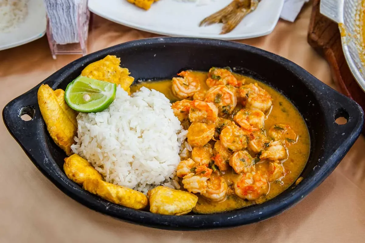 Encocado de camarones en salsa de coco con arroz y patacones