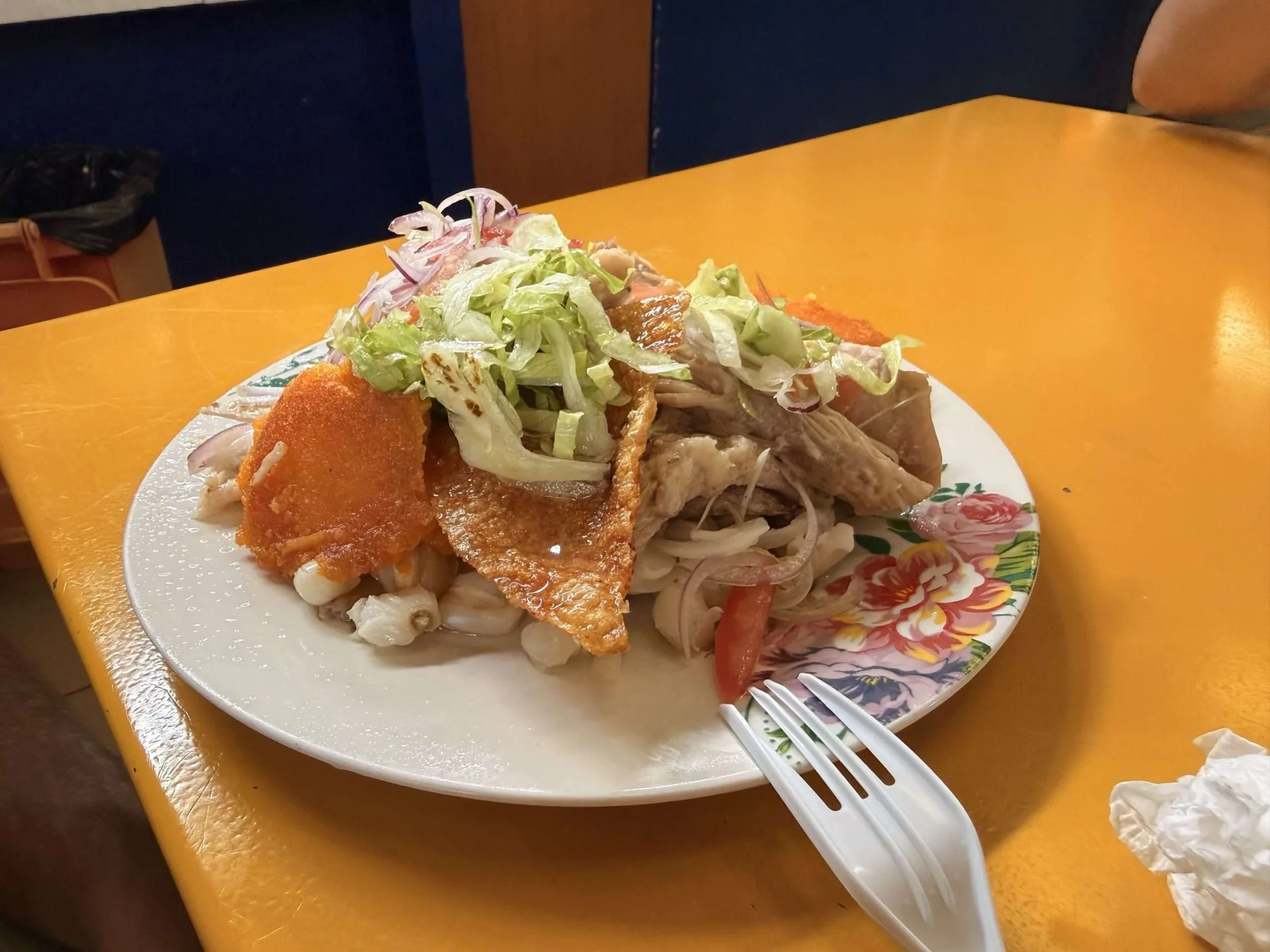 Plato de hornado con mote, cuero crocante, lechuga y tomate