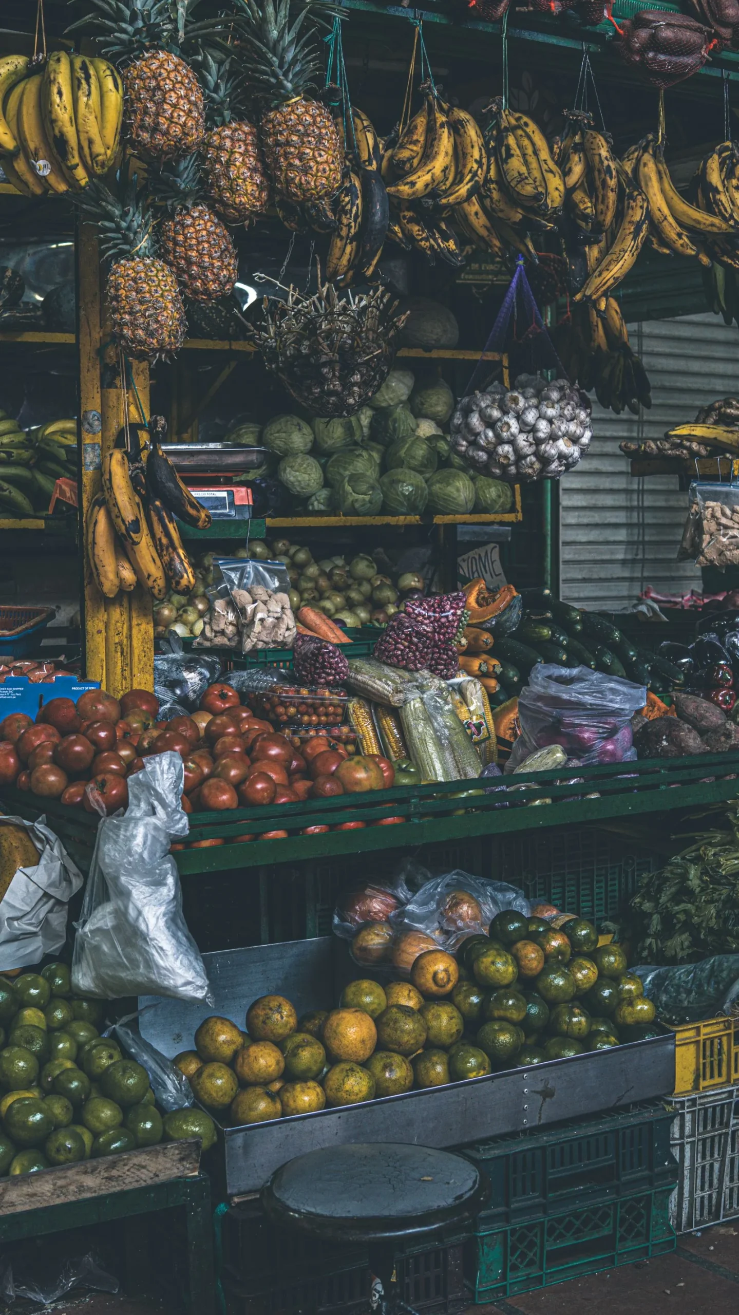Puesto de frutas tropicales en un mercado de Medellín, con piñas, plátanos y mangos