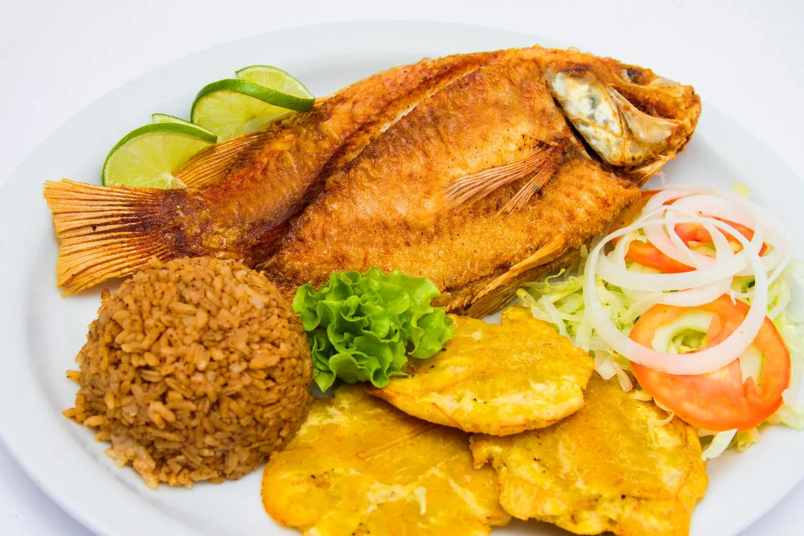 Mojarra frita entera con arroz con coco, patacones, ensalada y limón