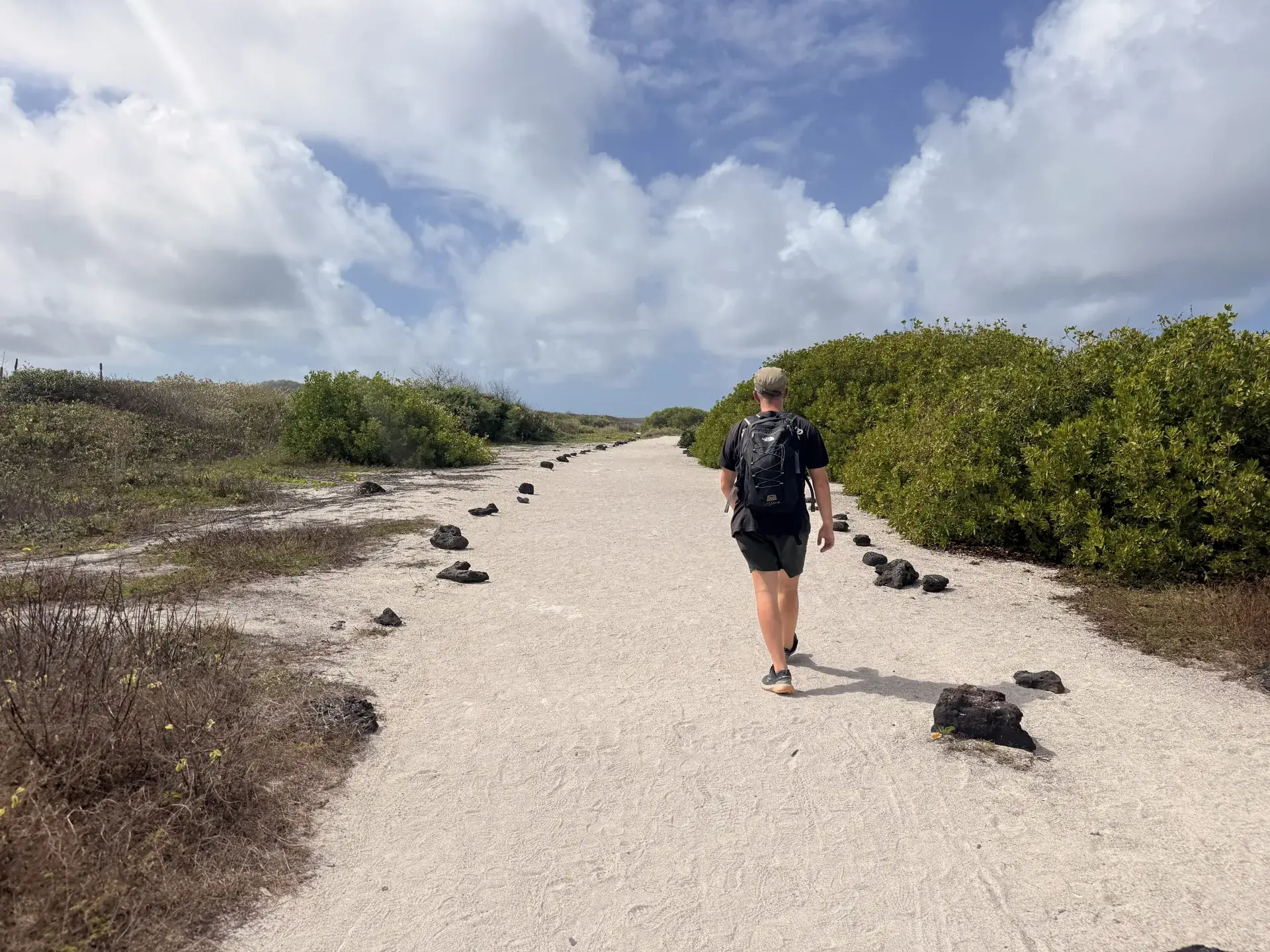 Hombre caminando por un camino de arena en Galápagos
