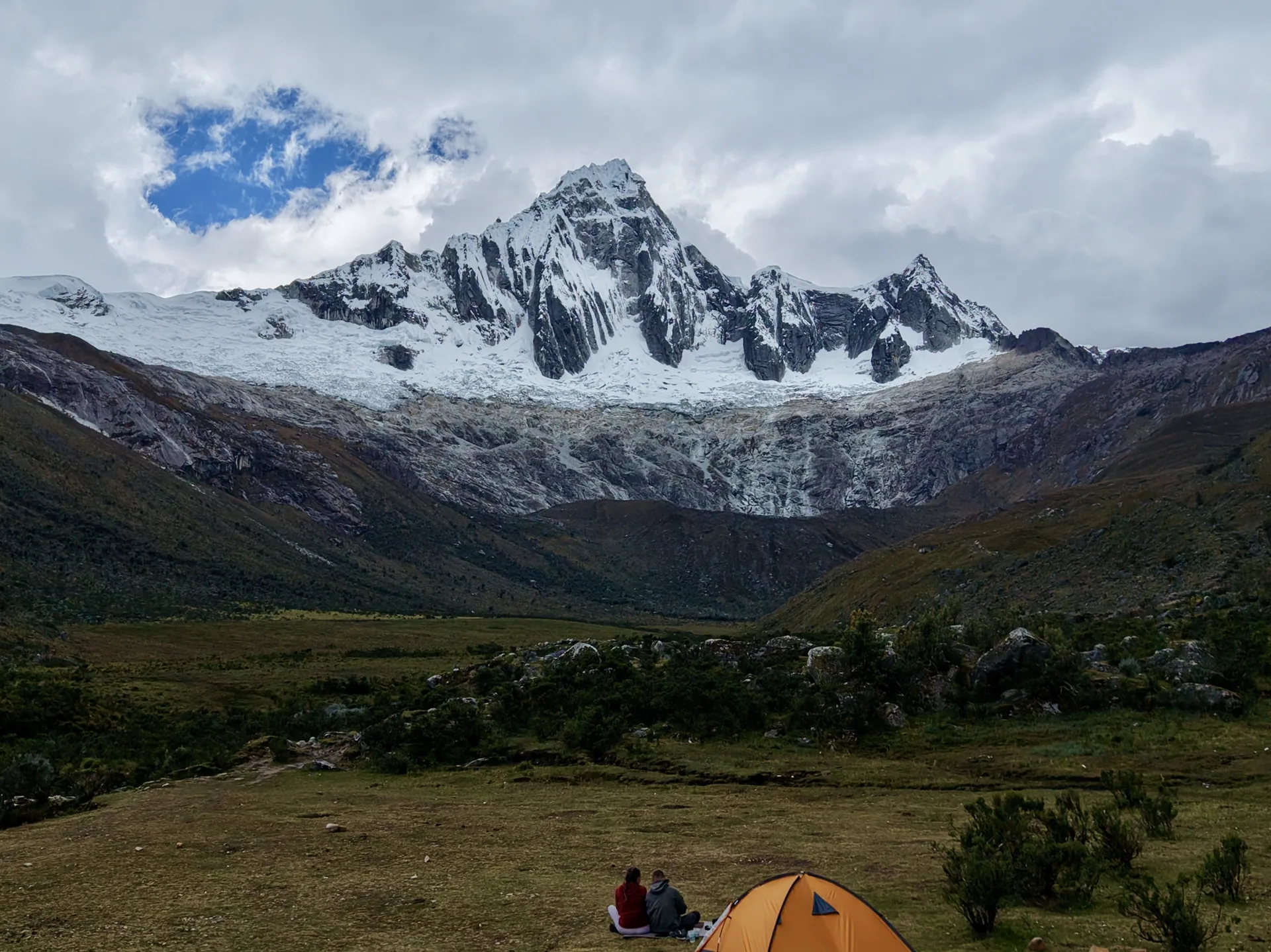 Pareja acampando frente montaña nevada en Santa Cruz Trek