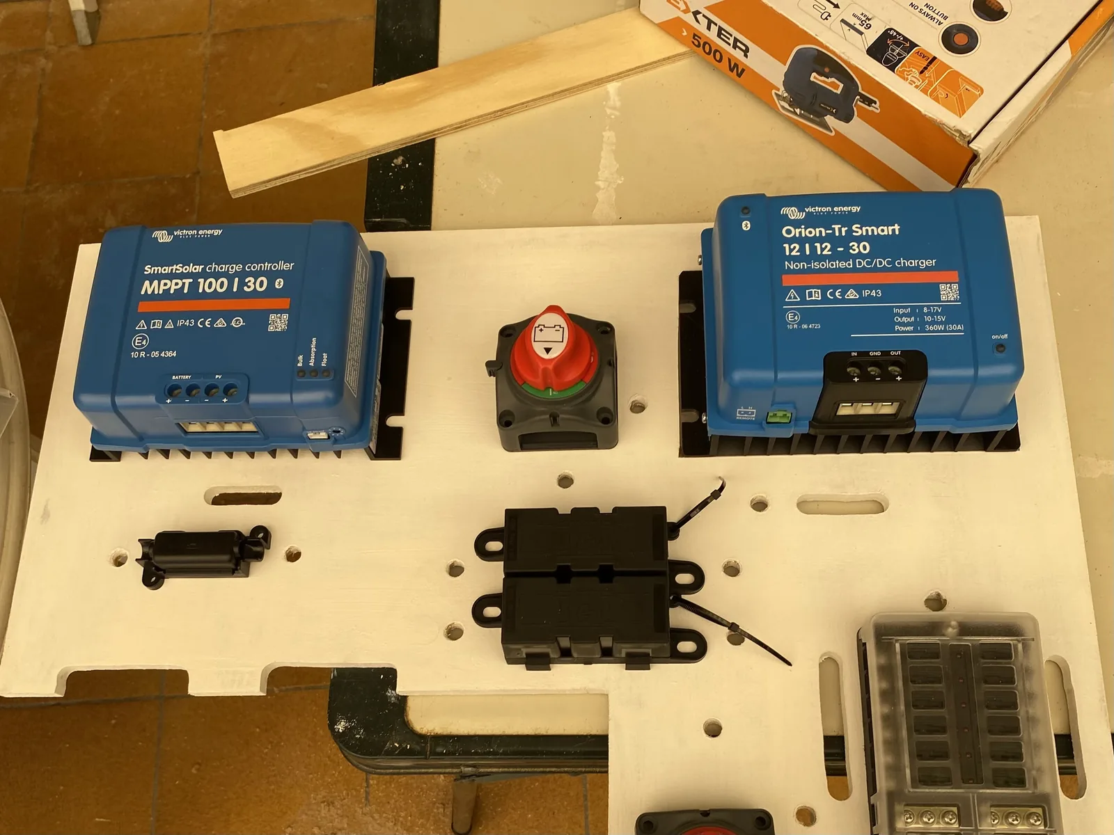 Regulador solar, cargador de batería, desconectador y caja de fusibles montados sobre una tabla blanca