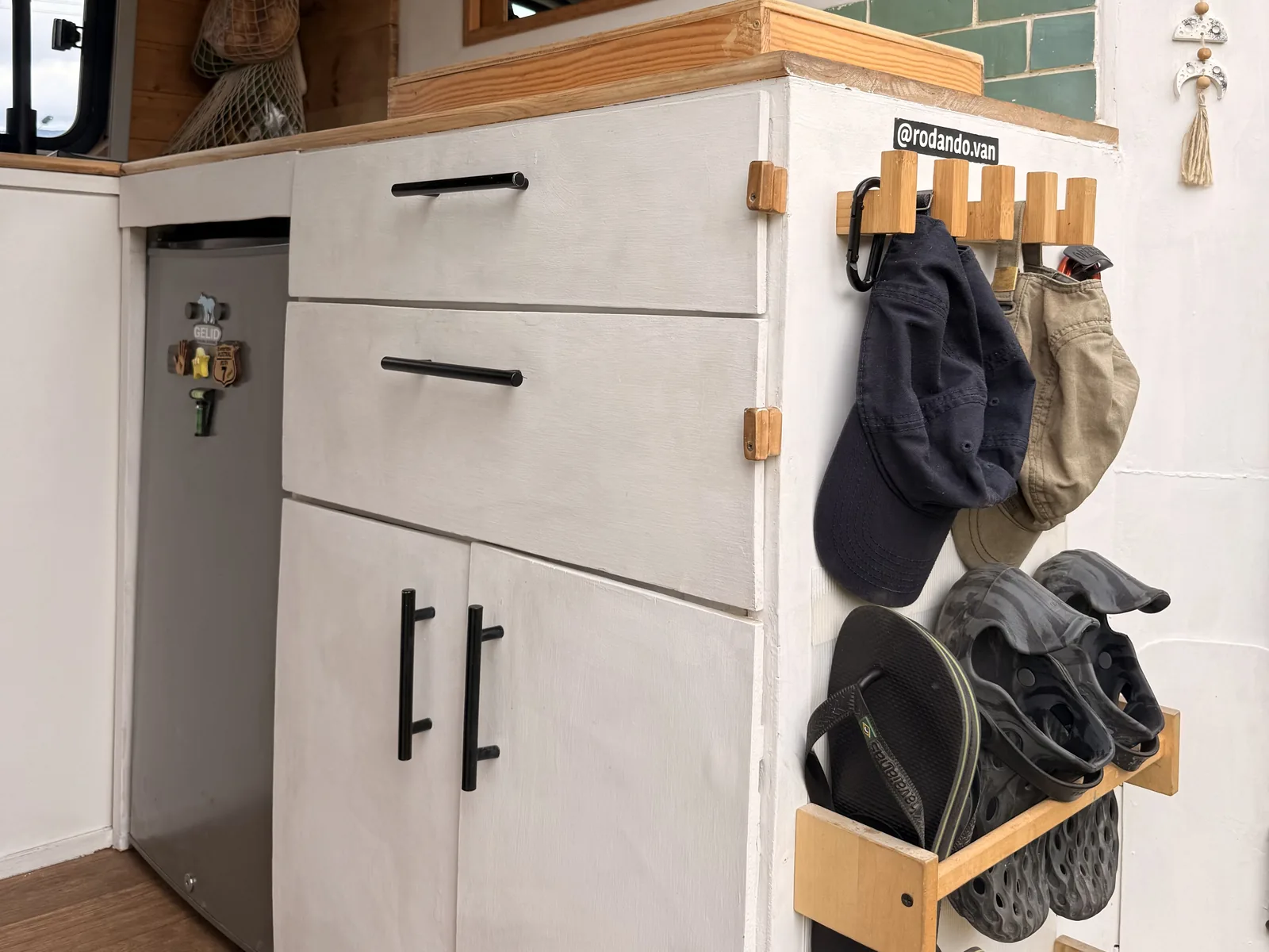 Mueble de cocina de la furgoneta con colgadores de madera para gorras y un soporte para chanclas